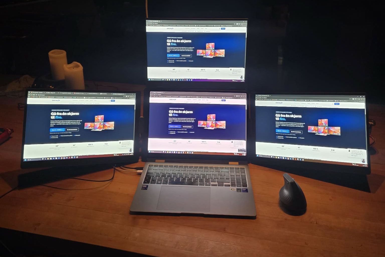Dockup Triple Pro i bruk hos en kunde — laptop med tre 16-tommers skjermer rundt seg, én over og én på hver side, på et kontorbord